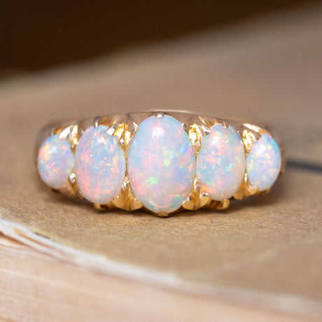 An antique, victorian precious white opal five-stone ring set in yellow gold.