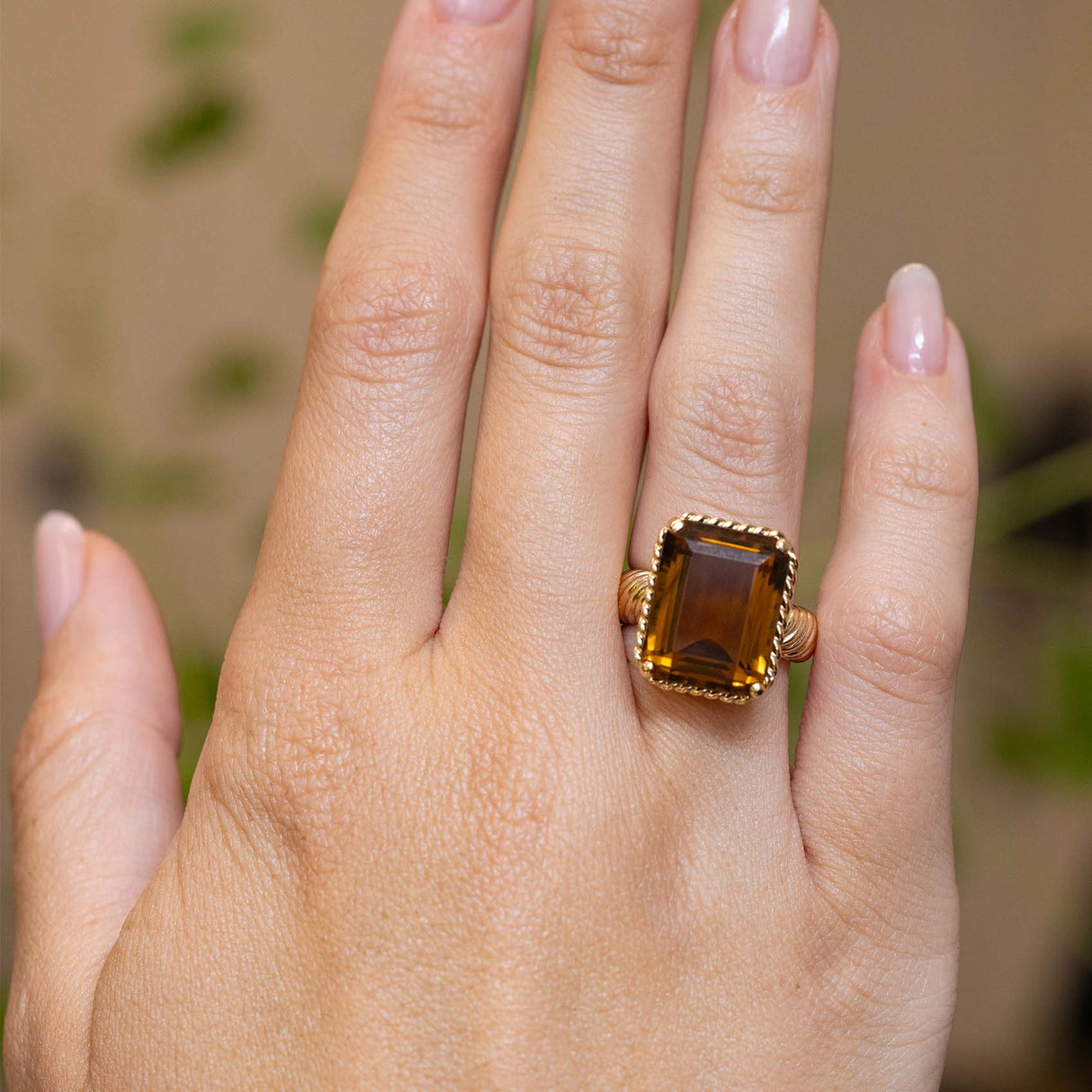 A vintage Cartier smoky quartz cocktail ring worn on the hand.
