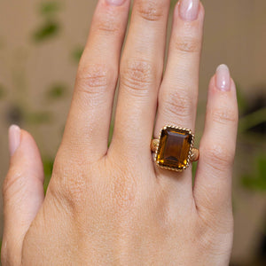 A vintage Cartier smoky quartz cocktail ring worn on the hand.