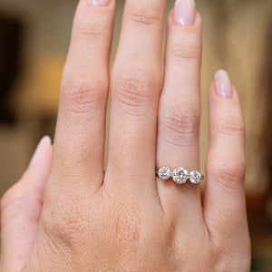 Edwardian diamond three-stone engagement ring shown at full scale on the hand