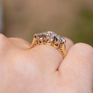 A side profile of the raised three-stone diamond setting worn on the finger.