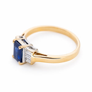 An angled view of a 1960s sapphire engagement ring with baguette-cut diamonds.