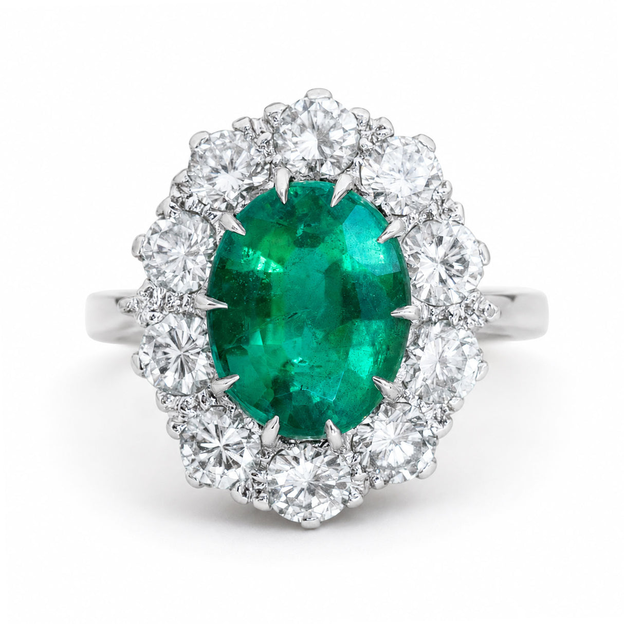 A vintage, 1950s oval emerald and diamond cluster engagement ring set in white gold.