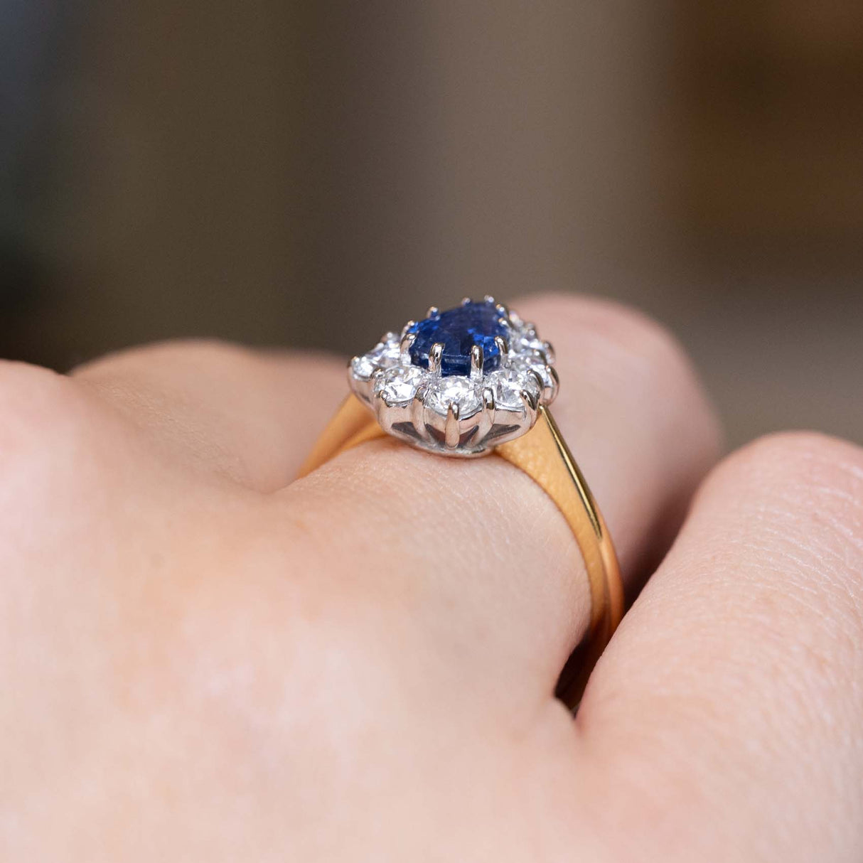 Angled side view of the sapphire cluster ring with a yellow gold band