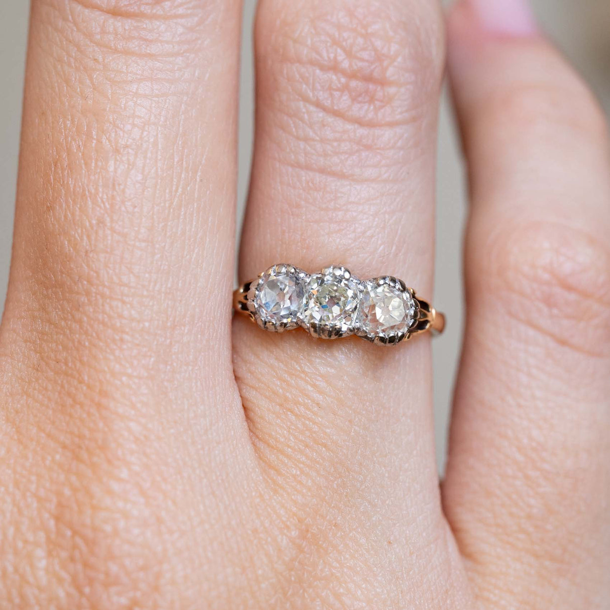 Close-up of an antique Victorian three-stone diamond ring on the finger