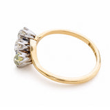 Angled view of an Art Nouveau three-stone diamond ring in yellow gold