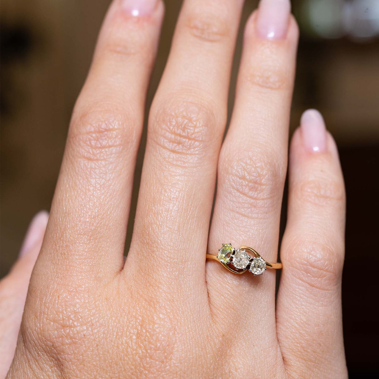 Art Nouveau diamond engagement ring shown at full scale on the hand