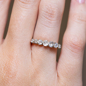 Antique seven-stone diamond engagement ring worn on the finger