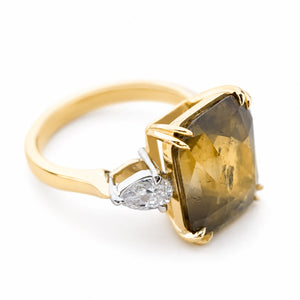 Angled view of a cushion-cut brown sapphire flanked by pear-shaped diamonds