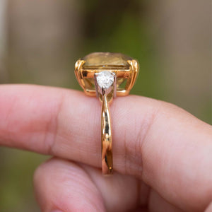Side view showing the raised sapphire setting and pear-shaped side diamond