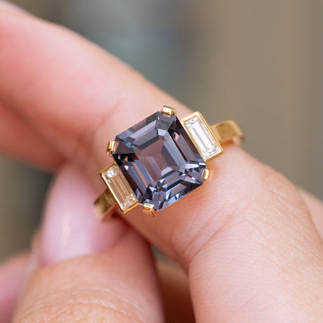 Close-up of an emerald-cut blue spinel flanked by baguette diamonds