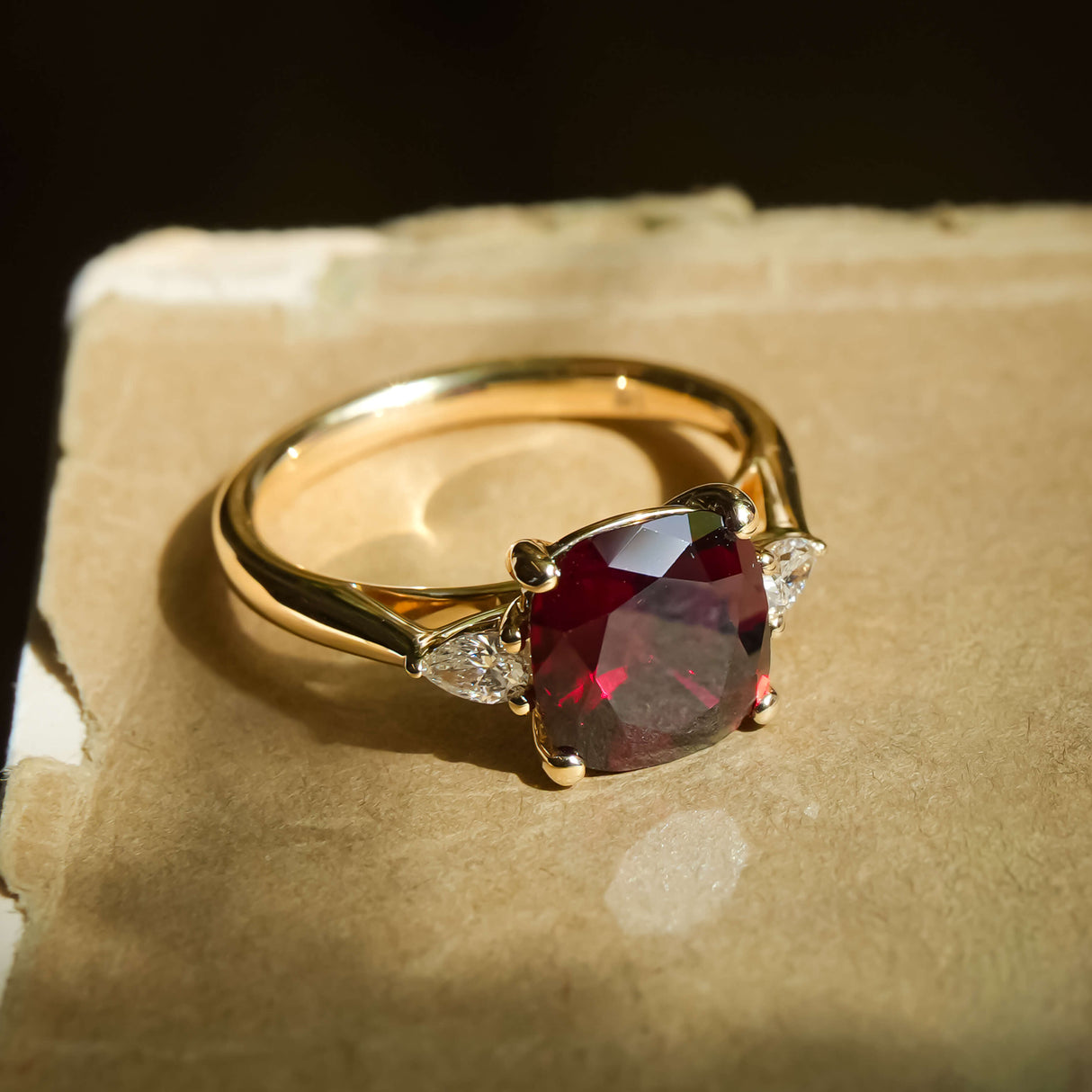 3ct cushion cut ruby and diamond three stone engagement ring in yellow gold band