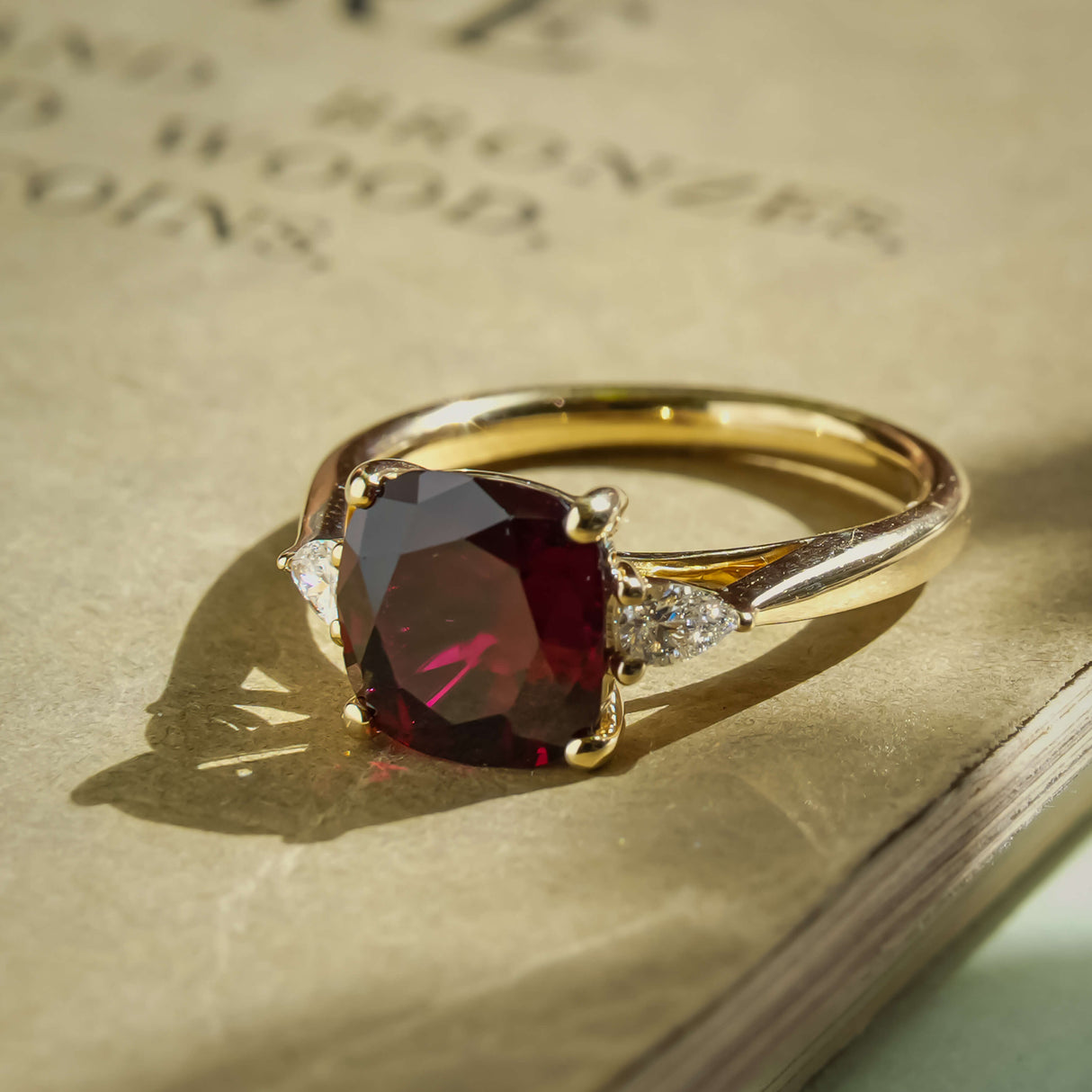 3ct cushion ruby and diamond three stone engagement ring in classic yellow gold setting