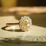 Oval yellow sapphire and diamond cluster engagement ring in yellow gold band