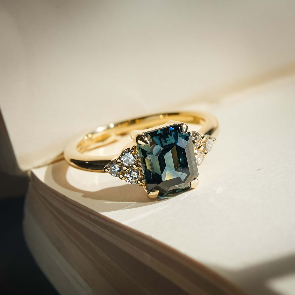 Teal sapphire and diamond cluster tre-foil engagement ring