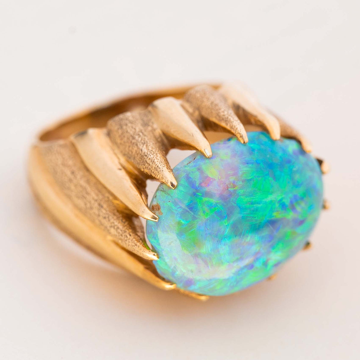 Three-quarter view of a vintage 1970s cabochon Australian opal ring in yellow gold.
