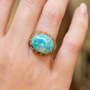 A vintage 1970s cabochon Australian opal ring worn on the finger.