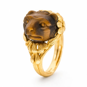 A Vintage, 1980's French tiger's eye honey bear carved yellow gold ring on a white background