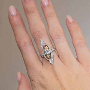 Antique Art Nouveau diamond cross-over ring worn on the finger, showcasing its elongated, flowing diamond-set design.