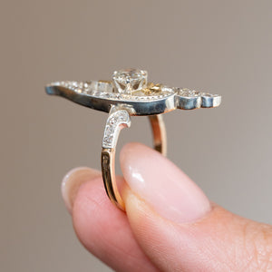Side profile of an antique Art Nouveau diamond cross-over ring showing the elevated setting, platinum detailing and yellow gold shank.