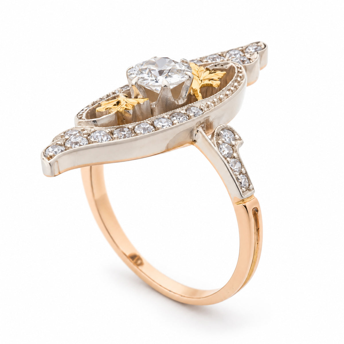 Side angle of an antique Art Nouveau diamond cross-over ring, showing its raised diamond setting, intricate platinum detailing and yellow gold band.