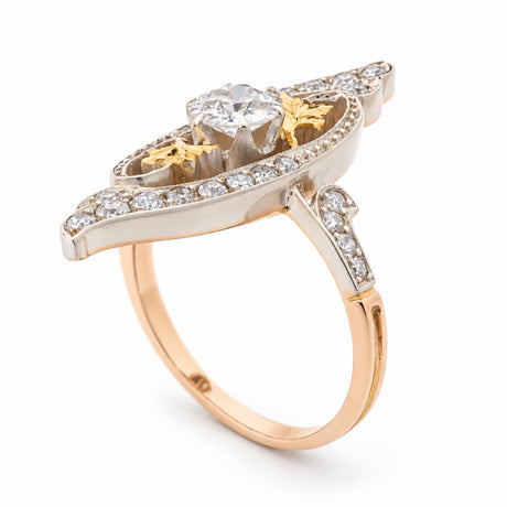 Side angle of an antique Art Nouveau diamond cross-over ring, showing its raised diamond setting, intricate platinum detailing and yellow gold band.