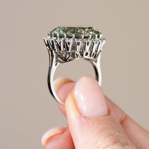 Profile photograph of the vintage white gold cluster ring, showing its ornate openwork gallery and elevated gemstone setting.