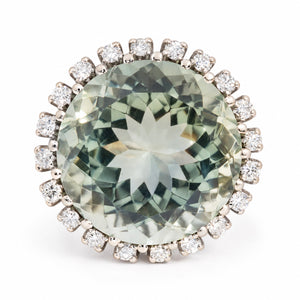 Vintage green quartz and diamond cluster ring in white gold, featuring a large oval green gemstone encircled by sparkling diamonds.