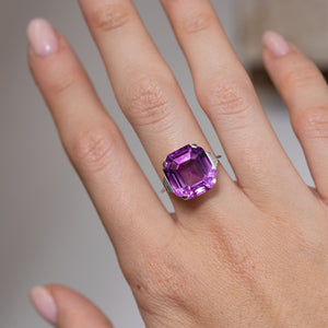 Purple amethyst cocktail ring worn on a hand, showcasing its striking gemstone and bold vintage proportions.
