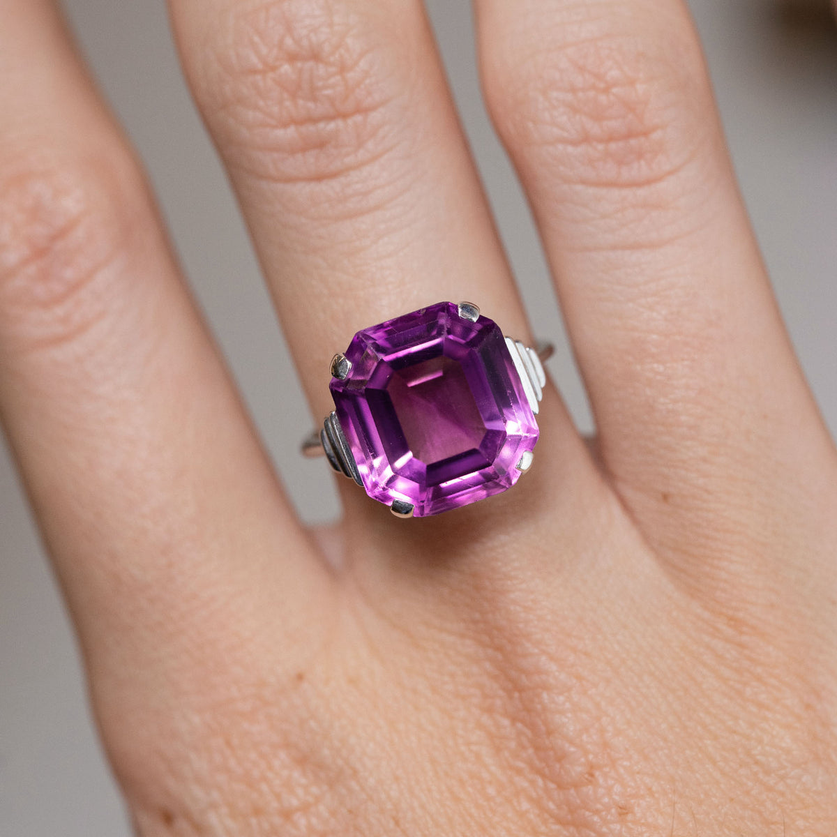 Close-up of the emerald-cut purple amethyst in white gold, showcasing its geometric shape and elegant Art Deco design.