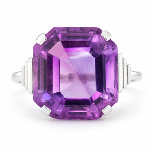 Antique Art Deco amethyst cocktail ring in white gold, featuring a large emerald-cut purple amethyst and geometric stepped shoulders.