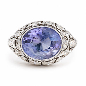 Antique, Belle Époque Ceylon colour-change sapphire and diamond cluster ring in platinum against a plain white background