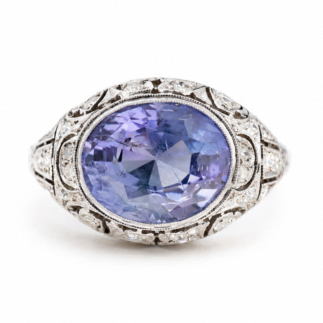 Antique, Belle Époque Ceylon colour-change sapphire and diamond cluster ring in platinum against a plain white background