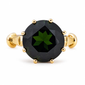 A Vintage, 1980's green tourmaline solitaire cocktail ring in yellow gold, photographed on a white background.