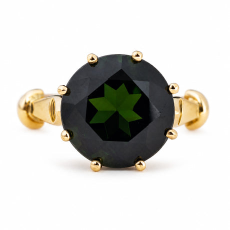 A Vintage, 1980's green tourmaline solitaire cocktail ring in yellow gold, photographed on a white background.