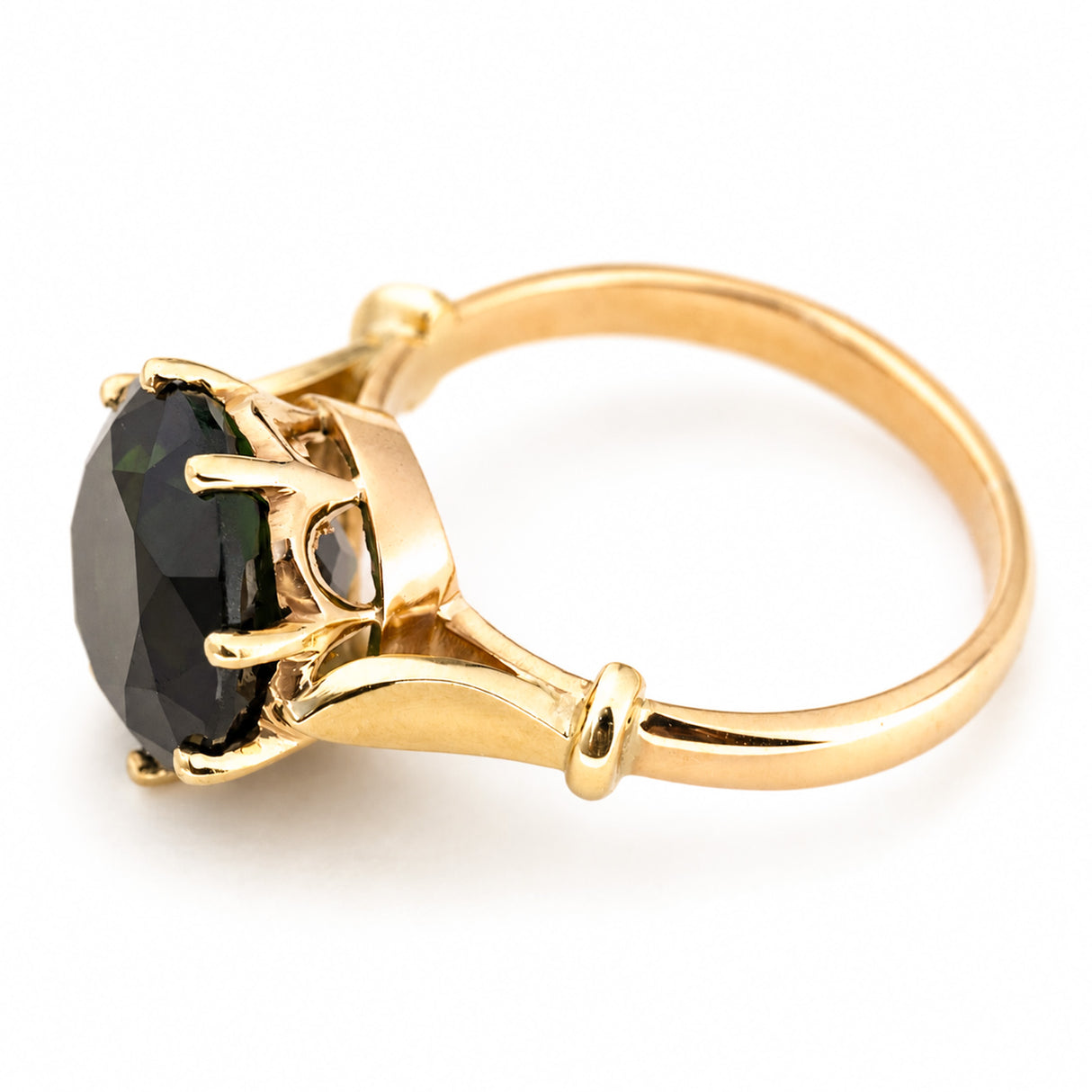 A vintage 1980s cocktail ring in yellow gold featuring a large, faceted green tourmaline in a claw setting, shown on a clean white background.
