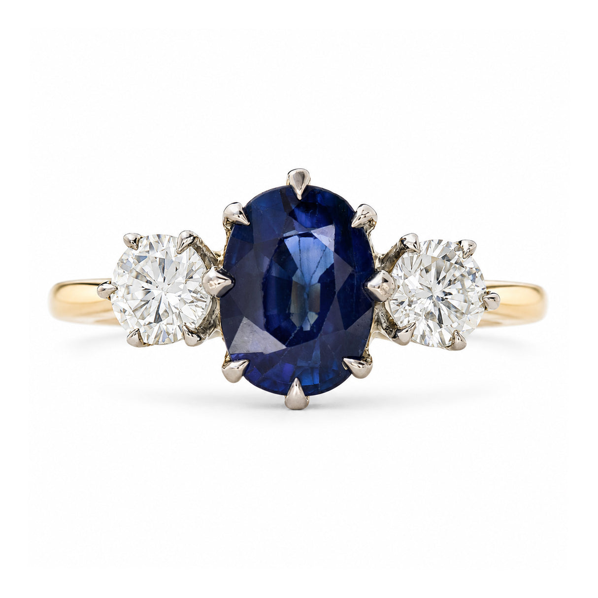 A yellow gold Antique, Art Deco sapphire and diamond three-stone engagement ring set on a plain white background.