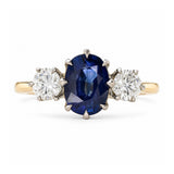 A yellow gold Antique, Art Deco sapphire and diamond three-stone engagement ring set on a plain white background.