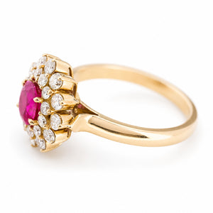 A vintage yellow gold ring featuring a round ruby centre stone surrounded by a double halo of diamonds, shown on a plain white background.