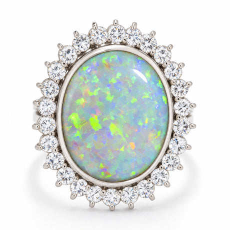 Vintage opal and diamond cluster cocktail ring in white gold, featuring a large oval opal surrounded by sparkling diamonds.