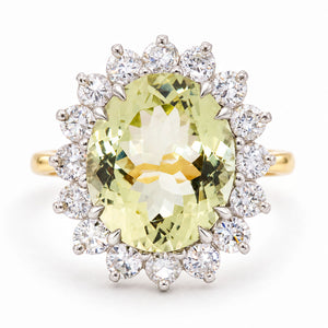 A Vintage, 1960s Green beryl and diamond cluster engagement ring on a yellow gold band white background.