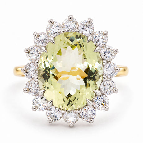 A Vintage, 1960s Green beryl and diamond cluster engagement ring on a yellow gold band white background.
