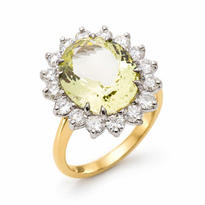A yellow gold Vintage, 1960s Green beryl and diamond cluster engagement ring shown on a clean white background as if standing at an angle showing off the gold shank.