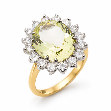 A yellow gold Vintage, 1960s Green beryl and diamond cluster engagement ring shown on a clean white background as if standing at an angle showing off the gold shank.