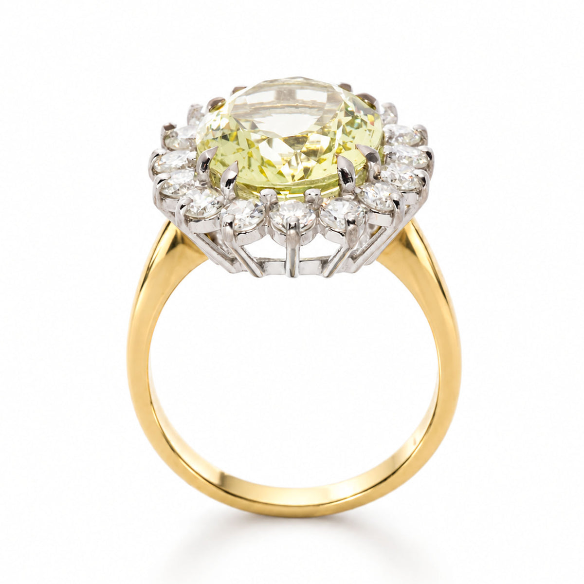 A Vintage, 1960s Green beryl and diamond cluster engagement ring on its side, displaying the full profile and yellow gold shank against a plain white background.