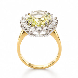 A Vintage, 1960s Green beryl and diamond cluster engagement ring on its side, displaying the full profile and yellow gold shank against a plain white background.