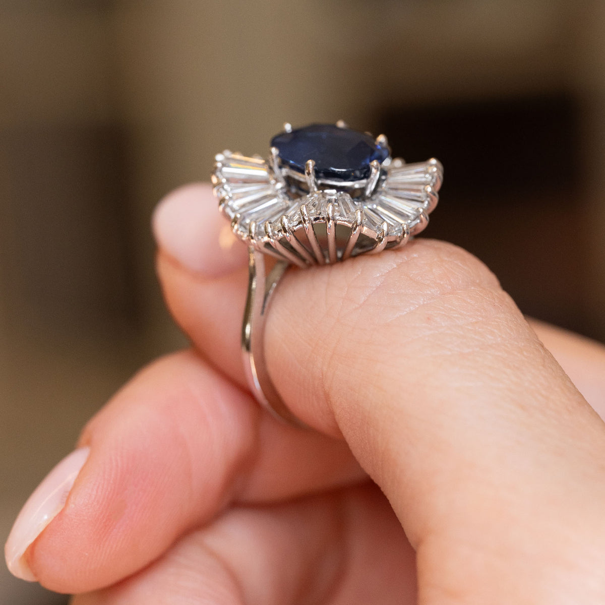Profile view of a vintage 1950s cocktail ring, highlighting the elevated sapphire setting and intricate white gold diamond gallery.