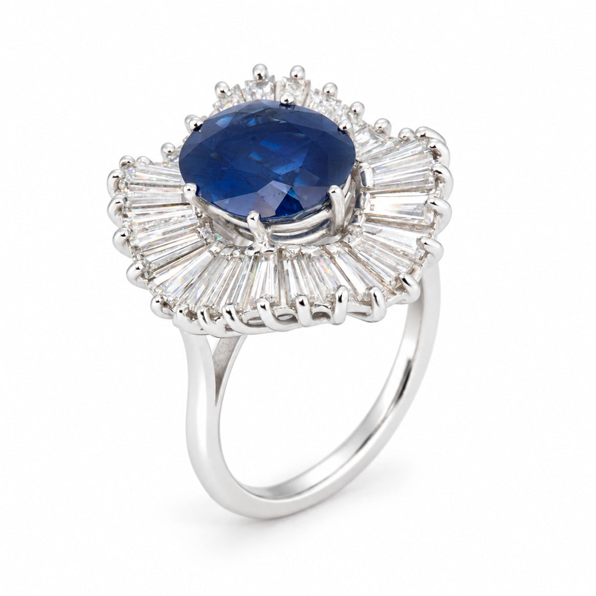 Angled product view of a vintage sapphire cocktail ring, featuring a deep blue centre stone framed by radiating baguette-cut diamonds.