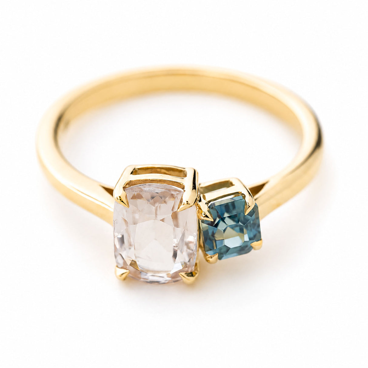 A yellow gold antique-inspired two stone toi et moi style sapphire engagement ring set on a plain white background and photographed from above to show the top of the ring.
