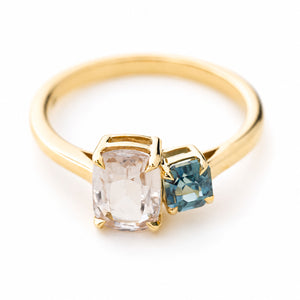 A yellow gold antique-inspired two stone toi et moi style sapphire engagement ring set on a plain white background and photographed from above to show the top of the ring.